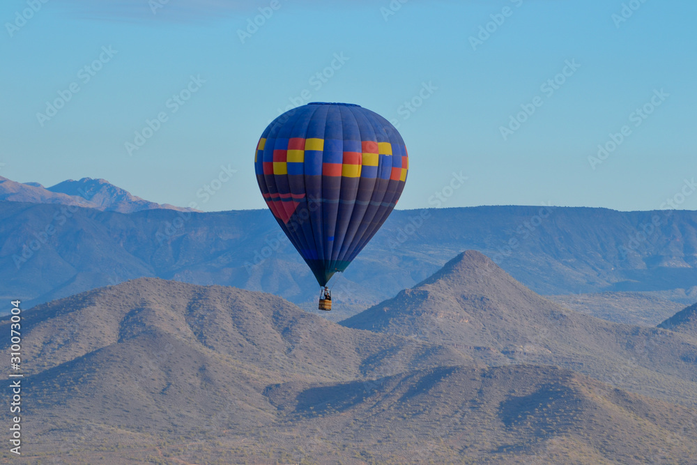 Hot Air Balloon floating over the Misty Mountains of the Arizona Desert near Phoenix