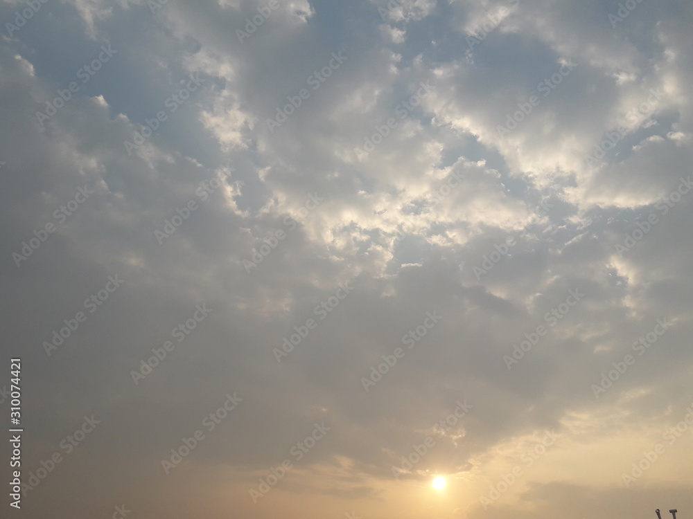 A view of sunrise with blue sky and puffy white clouds 
