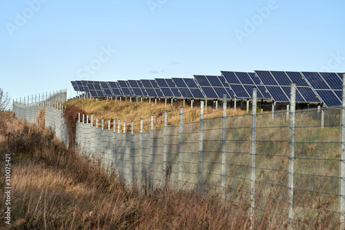 Wallpaper Mural green energy. solar panel field in the winter sun behind a fence. alternate energy. photovoltaic, blue sky, germany  Torontodigital.ca