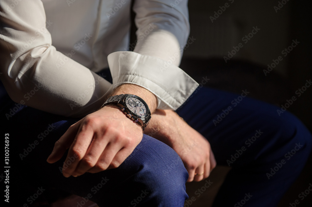 close up photo of groom's hands in a suit, a watch on the left hand