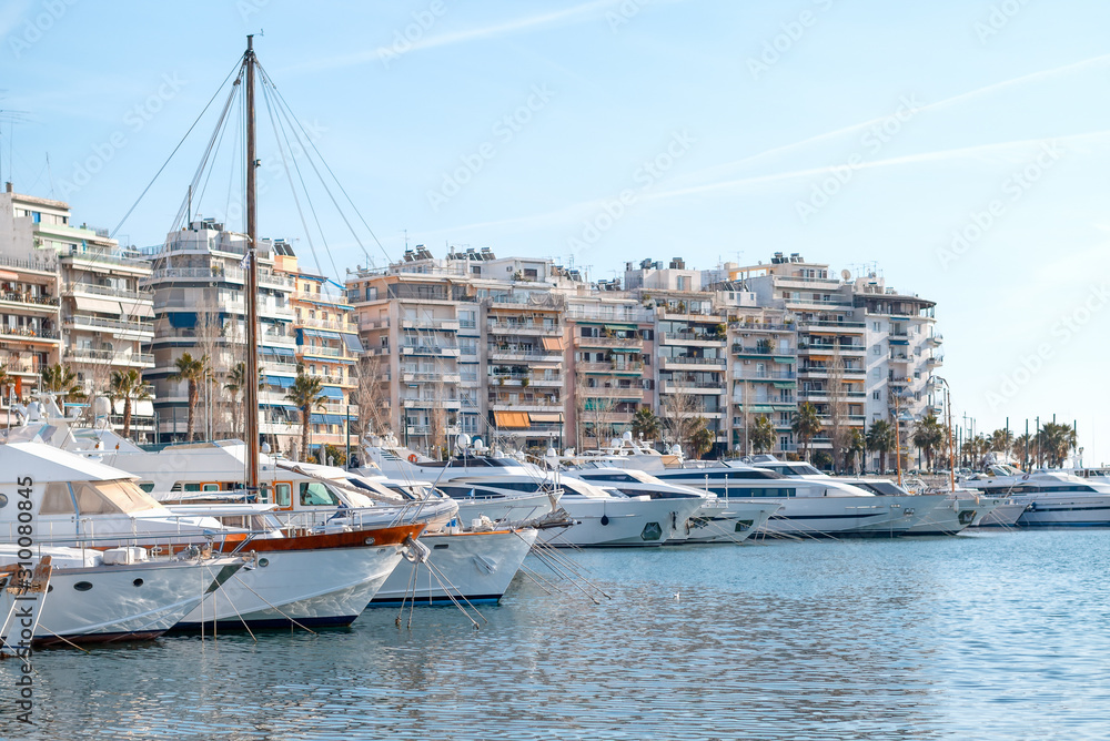 Pier with moored yachts in port. High class lifestyle. Luxury summer vacation. Balearic islands, Majorca. Maritime walking. Yachting sport. Marina with anchored sailboats. Houses on background.