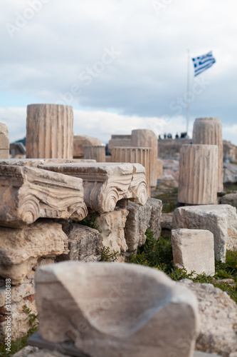 Vertical photo of fragments of the surviving parts of the Parthenon temple. Pieces of columns and capitals. Ruins of Parthenon. Acropolis Hill in Athens. Traveling and vacation concept.