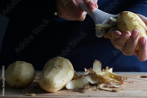A women show how to peel a potato using kitchen tool