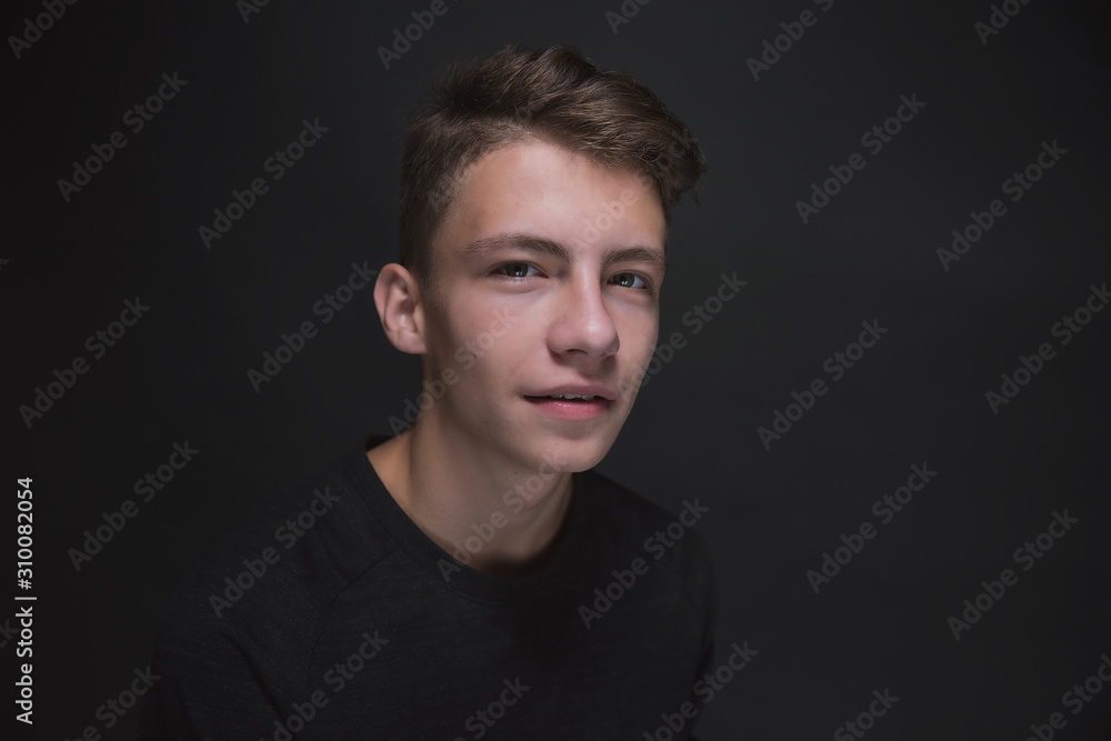 Beautiful young brown-haired man in a gray jacket, expressive and sensual portraits of a young man