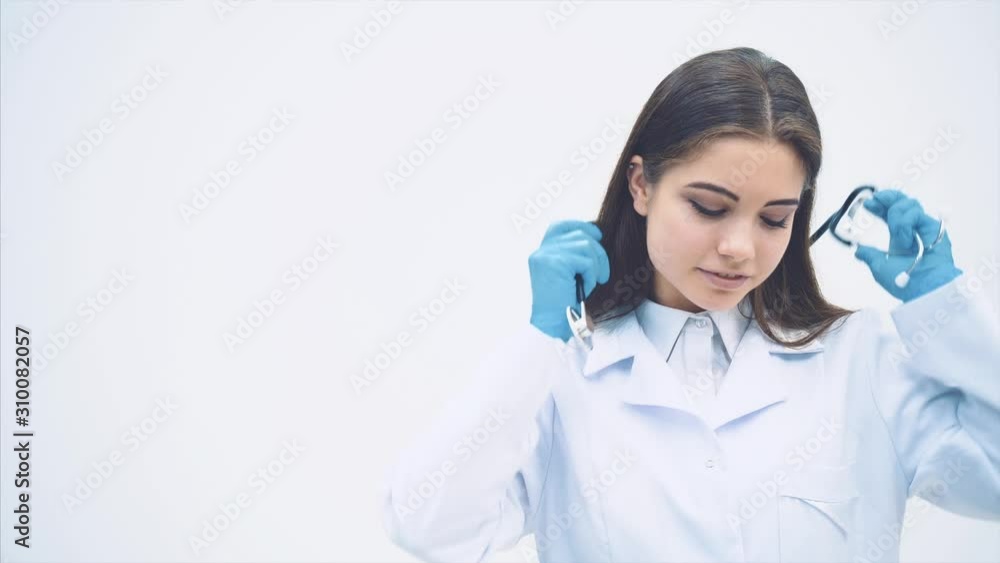 Lovely smiling female putting stethoscope over her neck, folding hands, looking confident. Lovely smiling female putting stethoscope over her neck, folding hands, looking confident.