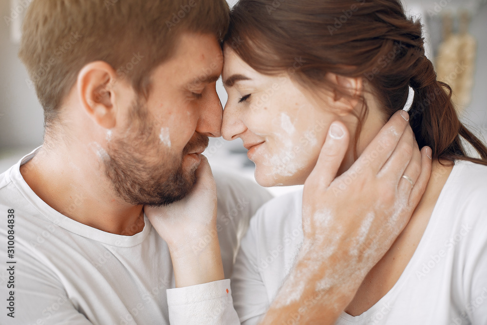 Fototapeta premium Cute couple in a kitchen. Lady in a white shirt. pregnant woman.