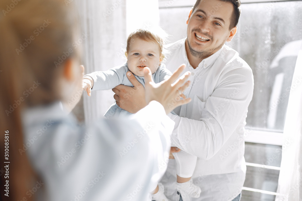 Cute family in a room. Lady in a white shirt. Little girl with parents Cute family in a room. Lady in a white shirt. Little girl with parents