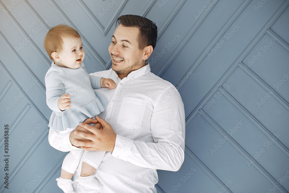 Handsome dad with child. Man in a white t-shirt. Little girl at home