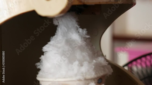 close up Woman hand making shaved ice with a machine.