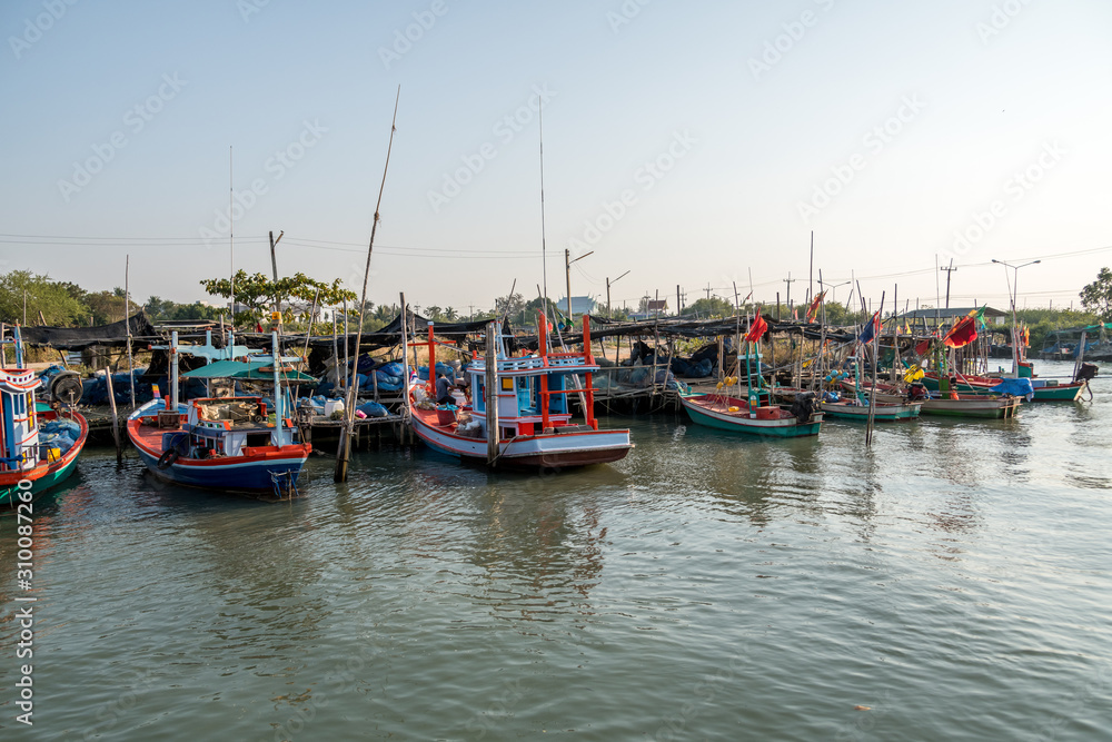 traditional fishing boats and floating village among beautiful sunset of Cha-am, Thailand