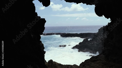 Cliffs and Pacific Ocean Landscape, View from Ana Kakenga Cave in Easter island, Chile. photo