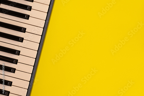 Top view piano keys over yellow background. pianist musician pianist concept.