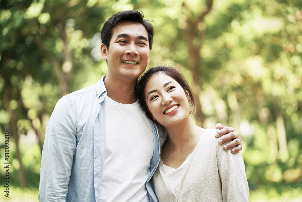 loving young asian couple relaxing outdoors in park loving young asian couple relaxing outdoors in park