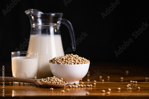 Soy milk hot and soybeans in cup on wooden table background