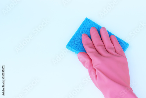 A female hand in pink gloves wipes the surface with blue rag.