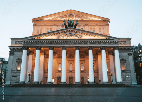 Front view of illuminated facade of Bolshoi Theater. A down-top view of white columns and grand top of Big Theatre in Moscow. Theatrical life. Tickets to russian opera and ballet. Architectural icon