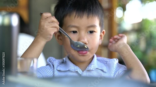 Asian boy about 3 year and 10 months eating stir fried rice or food by himself