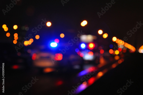 Blue light flasher atop of a police car. City lights on the background. © Александр Байдук