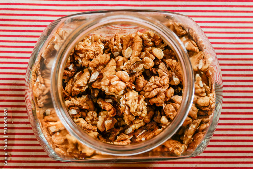 Obraz premium Stockholm, Sweden A big glass container of walnuts in a kitchen.