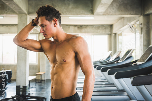 A handsome young man standing posing in a gym. Healthy concept