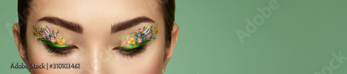 Eye makeup girl with a flowers. Spring makeup. Beauty fashion. Eyelashes. Cos...