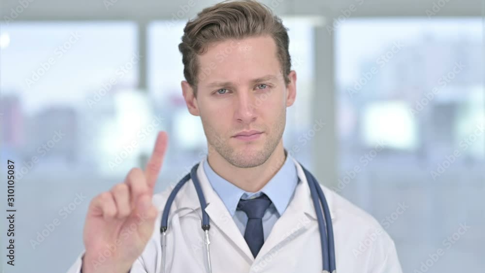 Portrait of Young Male Doctor saying No with Finger Sign Portrait of Young Male Doctor saying No with Finger Sign