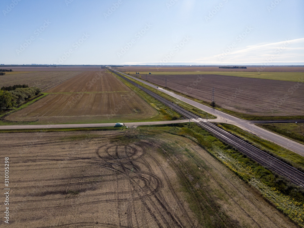 Aerial View of Farm Fields and Double Train Tracks Across Prairie