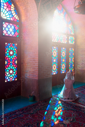  Young Muslim woman praying in Nasir Al-Mulk Mosque (Pink Mosque) photo