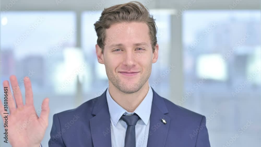 Portrait of Cheerful Young Businessman Waving at the Camera Portrait of Cheerful Young Businessman Waving at the Camera