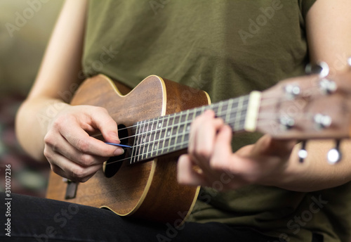 Girl playing the ukulele. Close up. Isolated on white background