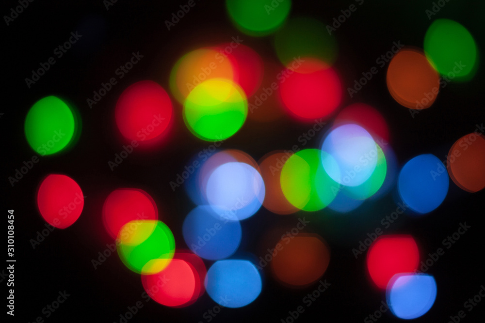 Abstract unfocused background - colorful bokeh of different bubbles on a black background. Modern blurred pattern for design and for Christmas, New year and funny holiday backdrops.. Abstract unfocused background - colorful bokeh of different bubbles on a black background. Modern blurred pattern for design and for Christmas, New year and funny holiday backdrops..