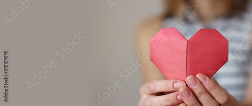 caucasian woman holding paper folded origami red heart. Insurance, charity donation concept. text area copy space, selective focus