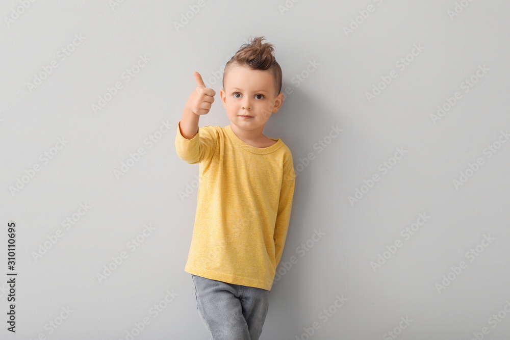 Portrait of cute little boy showing thumb-up on light background Portrait of cute little boy showing thumb-up on light background
