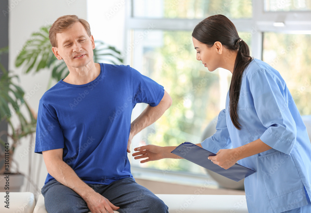 Obraz premium Physiotherapist working with male patient in rehabilitation center