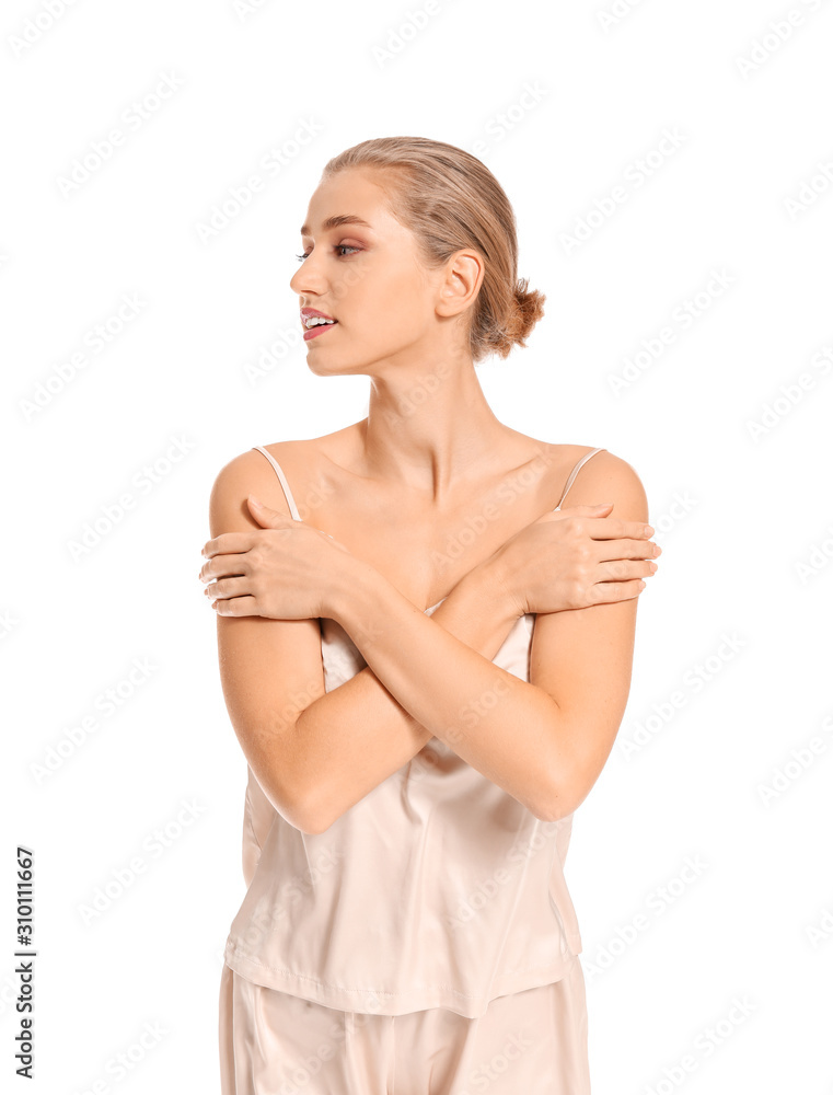 Obraz premium Beautiful young woman in pajamas on white background