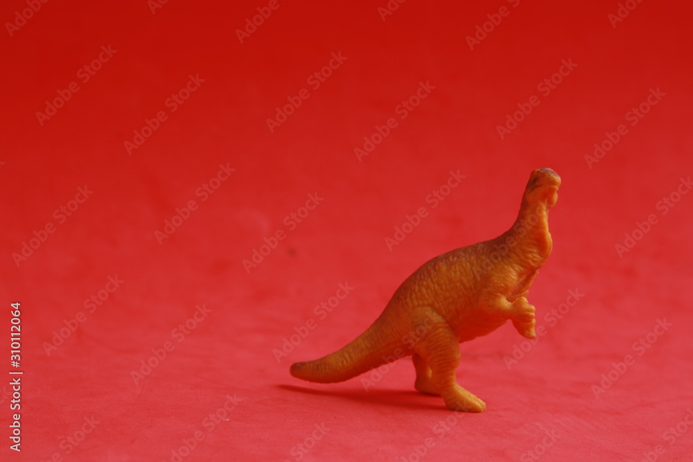 plastic toy with dinosaur shape in color background