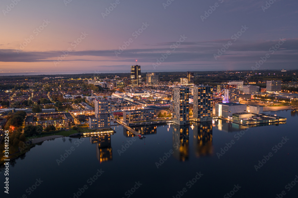 Obraz premium Almere city center illuminated at dusk. Aerial view.