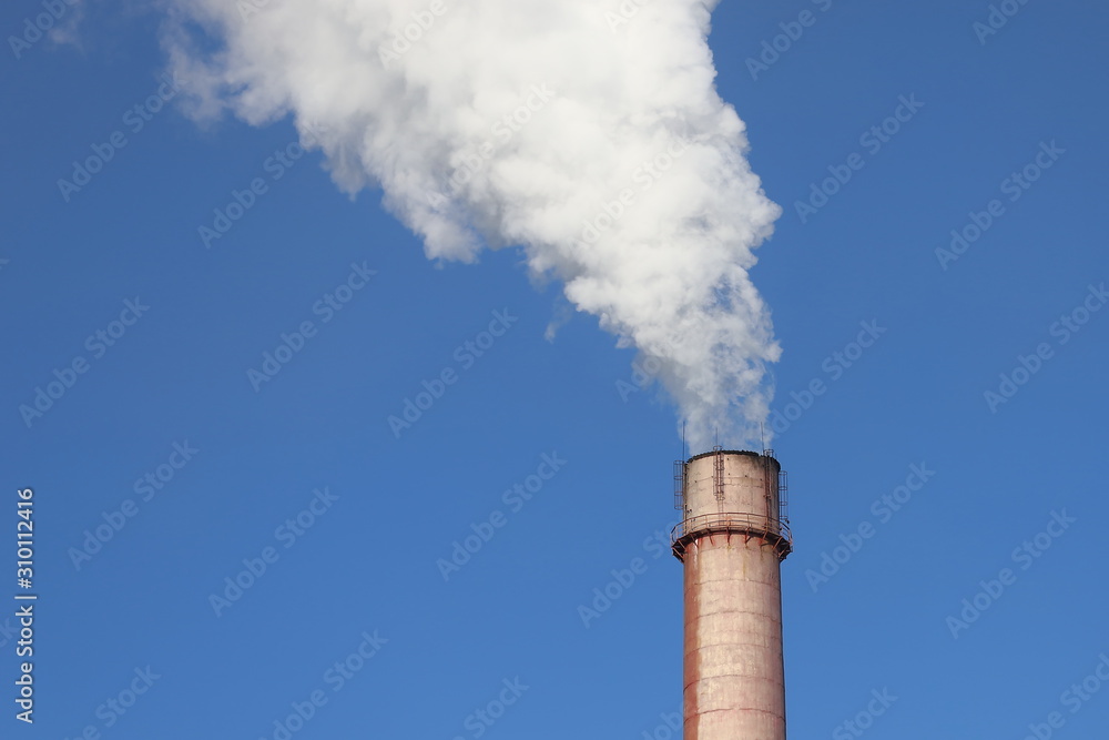Factory chimney smoking with dense white smoke on blue sky background. Industrial pollution of air, electric plant emission, environment ecology problem. Factory chimney smoking with dense white smoke on blue sky background. Industrial pollution of air, electric plant emission, environment ecology problem.