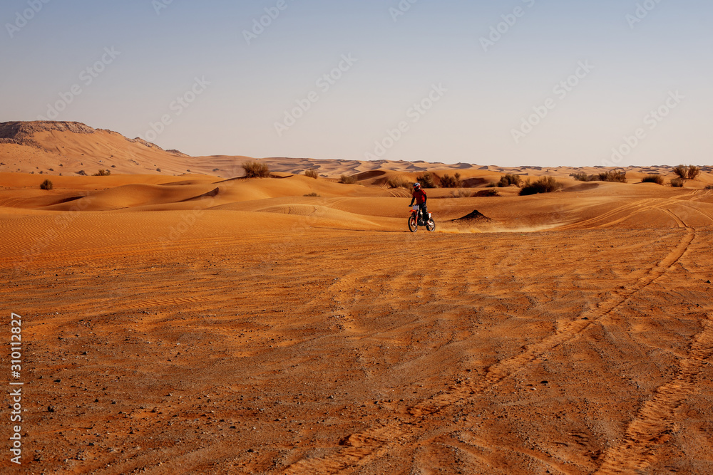 Professional motocross driver rides a motorcycle in the desert