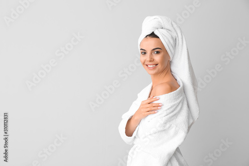 Beautiful young woman after shower on grey background