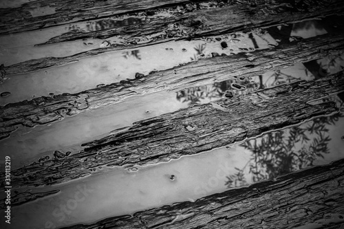 Puddle of water on the wet pathway in black and white