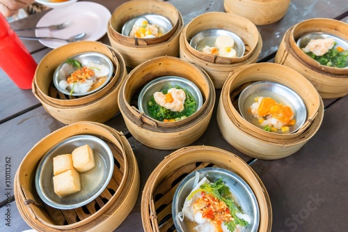 Thai Dim sum prawn placed in a traditional bambaoo steamer box.