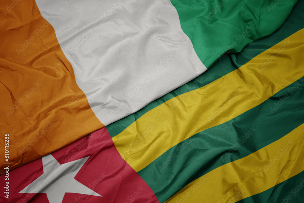 waving colorful flag of togo and national flag of cote divoire.