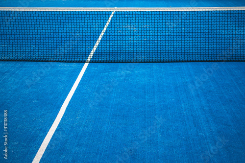 Blue paddle tennis net and court field background © vejaa