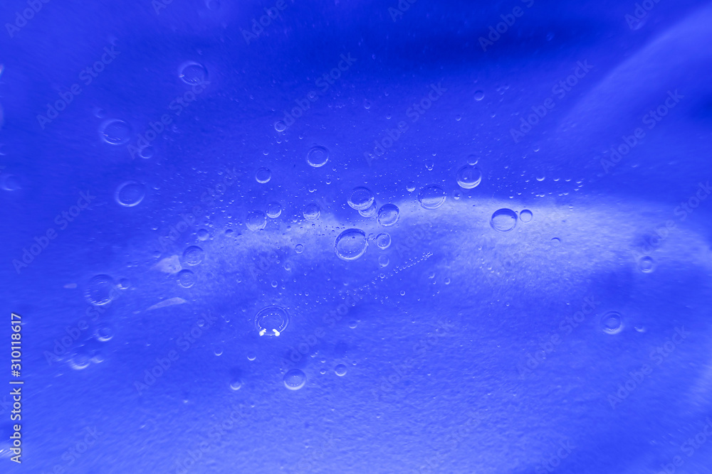 Cosmetic gel close-up. Macro photo. The concept of cosmetic products, skin and hair care, beauty and health. Background image in trendy blue. Cosmetic gel close-up. Macro photo. The concept of cosmetic products, skin and hair care, beauty and health. Background image in trendy blue.