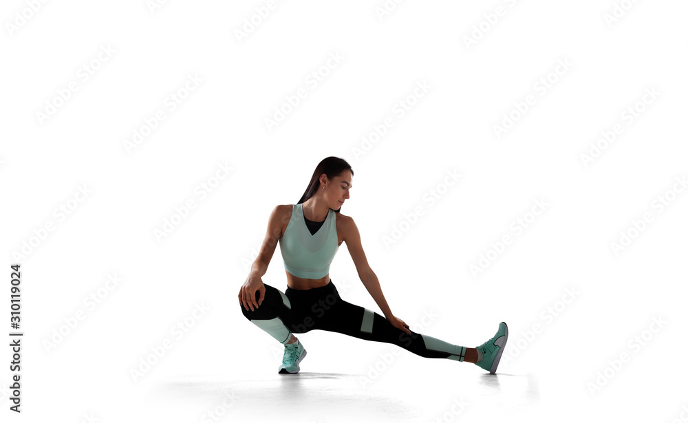 Female athlete running and jumping isolated on white.