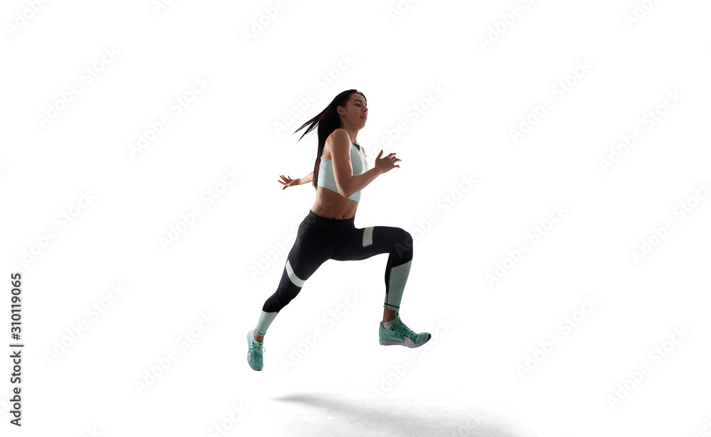 Female athlete running and jumping isolated on white.