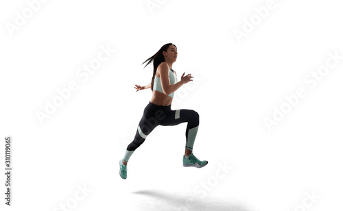 Female athlete running and jumping isolated on white.