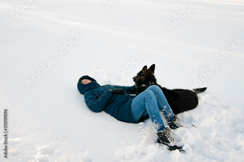 Girl with a dog on the shore of a winter lake.