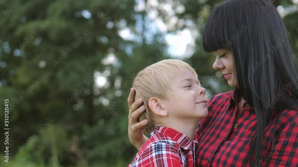 happy family mom and son concept . mom tender childhood video . slow motion video . lifestyle mom a brunette girl gently hugs takes care of the boy son blonde outdoors happy family mom and son concept . mom tender childhood video . slow motion video . lifestyle mom a brunette girl gently hugs takes care of the boy son blonde outdoors